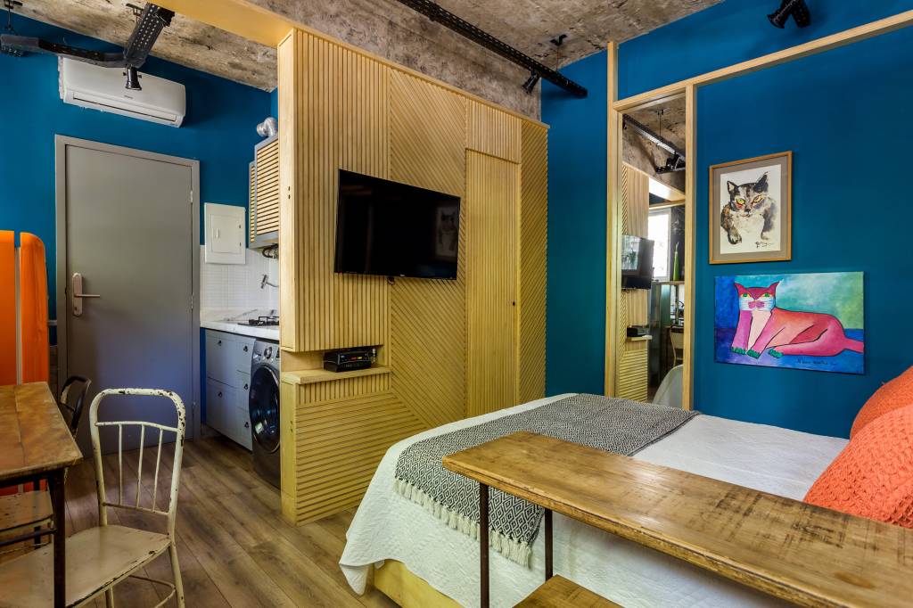 2-micro-loft-ganha-tijolinhos-e-geladeira-retro-laranja Mini loft com painel de madeira