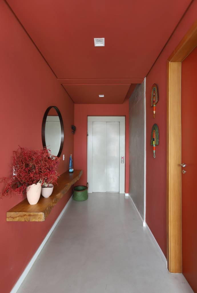 20-estilo-industrial-arte-e-integracao-marcam-este-apartamento-em-sao-paulo Hall de entrada vermelho com espelho redondo