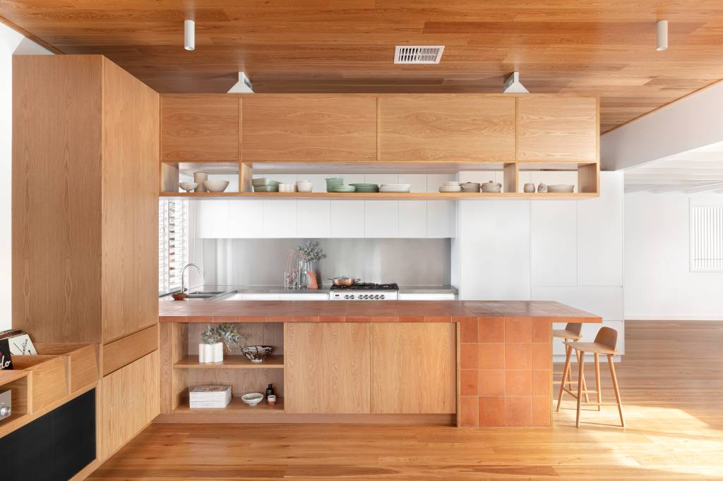 3-casa-recebe-extensao-contemporanea-com-detalhes-em-terracota Cozinha com ilha de madeira e base branca