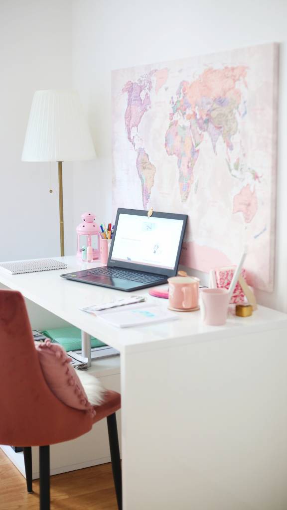 4-tendencias-novos-tempos-andrijana-bozic-home-office-quarto-menina-canto-estudos Foto mostra escrivaninha em quarto que sugere ser de uma menina ou adolescente. Na mesa branca há um laptop e objetos cor de rosa.