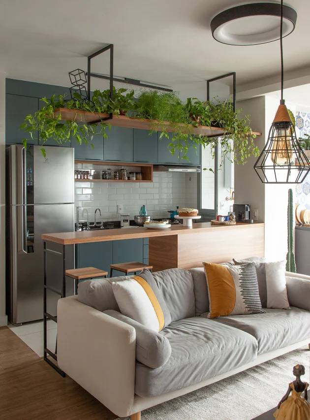 4-tendencias-novos-tempos-luis-gomes-sala-estar-e-jantar-plantas Foto mostra sala de estar e jantar integradas, com prateleira de plantas sobre sofá.