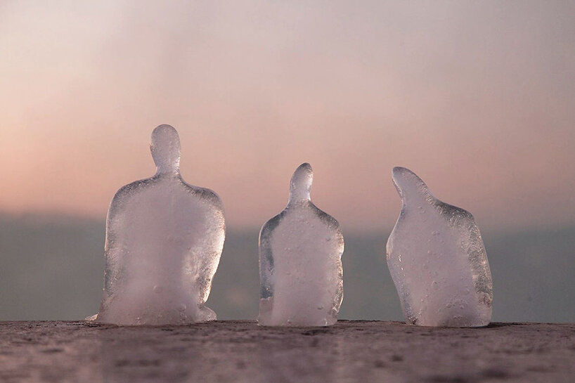 Essas esculturas de gelo alertam sobre mudanças climáticas-Designboom Néle Azevedo Pedro Palhares Pequenas esculturas de gelo derretendo de pessoas sentadas uma ao lado da outra de cabeças levemente baixas ao pôr do sol.