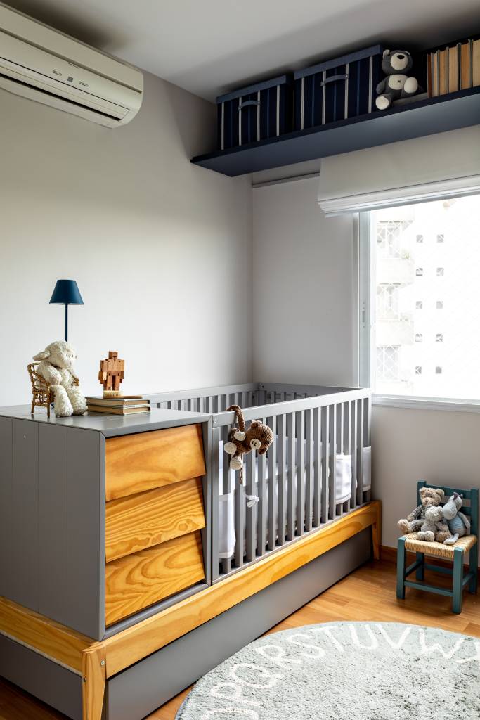 apartamento-pinheiros-quarto-infantil Quarto infantil tem prateleira aérea, grande berço cinza com gavetas de madeira