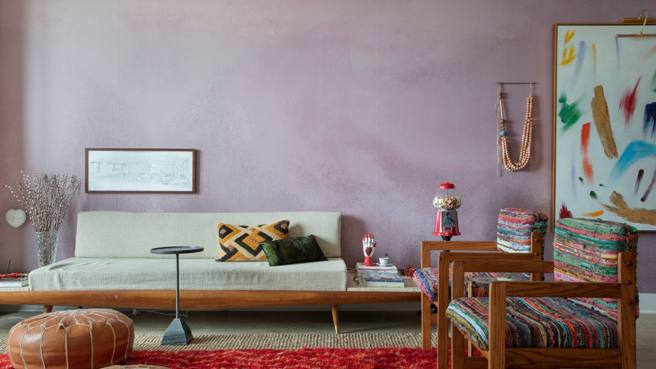 Sala em estilo Boho; sofá branco; parede em rosa queimado e tapete vermelho