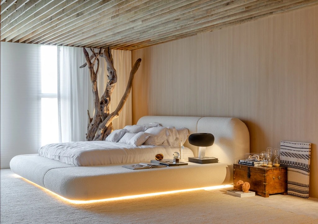 Quarto de casal com cama baixa e fita led sob colchão, na altura do tapete.