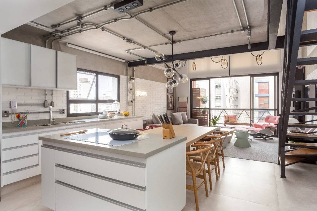 conheça-vantagens-tubulação-aparente-JP-Image-cozinha-sala-estar-tubulação-aparente-estilo-industrial Foto mostra cozinha integrada à sala de estar com tubulação aparente em tom prateado, combinando com paleta de cores neutras e tons claros.