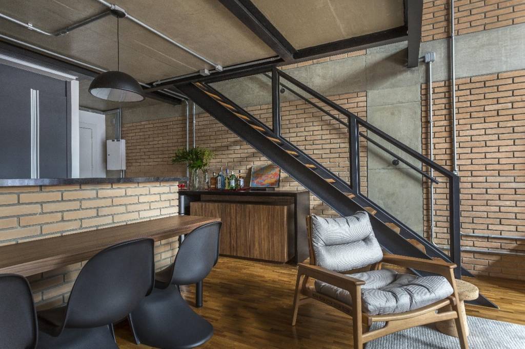 conheça-vantagens-tubulação-aparente-JP-Image-sala-estar-tubulação-aparente-estilo-industrial Foto mostra sala de estar com escada e tubulação aparente compondo o visual em estilo industrial.