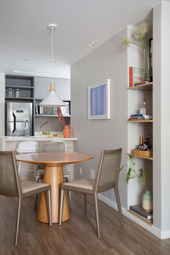 Sala de jantar com mesa redonda de 4 lugares; cozinha ao fundo