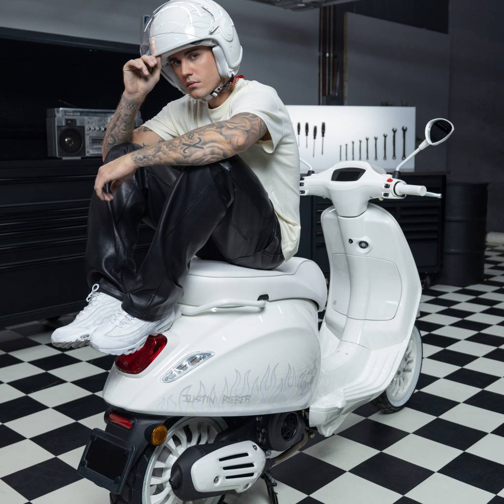 10 peças de design criadas por celebridades Dezeen (4) Justin Bieber posa sentado sobre scooter branca.