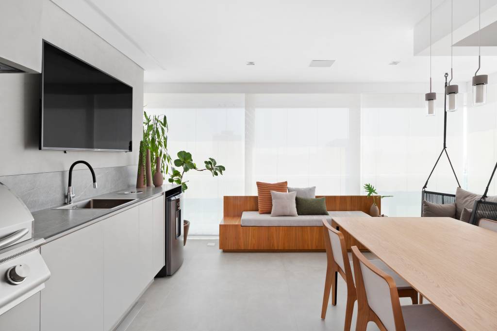Ape-de-160-m2-se-destaca-pela-combinação-de-cinza-e-tons-terrosos-Projeto-Doob-Arquitetura-Foto-Julia-Ribeiro-churrasqueira-banco-mesa-cinza Varanda com banco e mesa