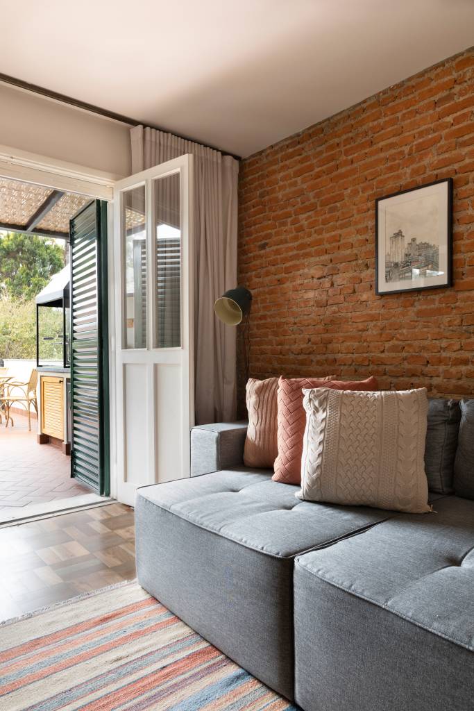Azulejos-e-tijolinhos-marcam-casa-de-200-m2-Projeto-Vinicia-Brandão-Arquitetura-Foto Carolina-Mossin-sala-de-tv-parede-tijolinhos Sala de tv integrada com área externa