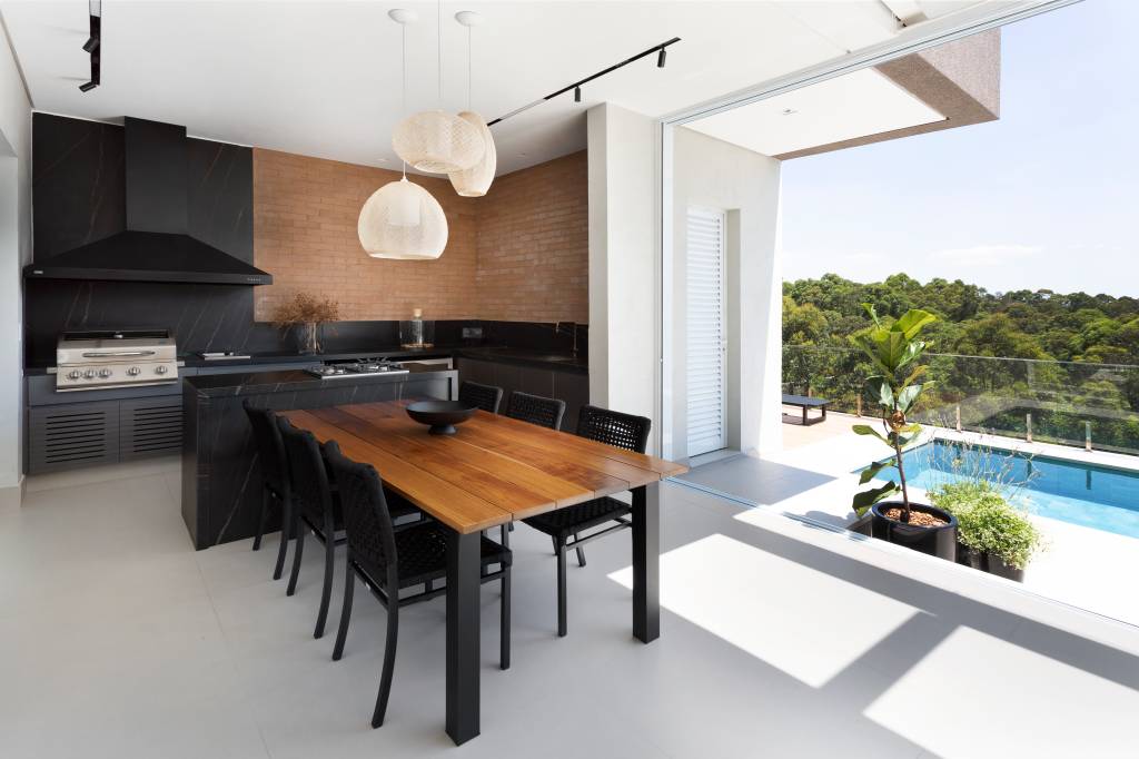 Casa-de-580-m²-destaca-a-paisagem-e-valoriza-a-natureza-projeto-Studio-Deux-Julia-Ribeiro-area-gourmet-churrasqueira-piscina Luminárias de destaque em mesa de churrasqueira