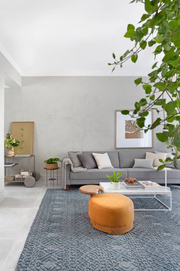 Cozinha-com-marcenaria-rosa-é-destaque-neste-apê-Projeto-Ana-Toscano-Arquitetura-Foto-Julia-Ribeiro-sala-de-estar-pufe-tapete Sala de estar com carrinho com flores, arte e livros