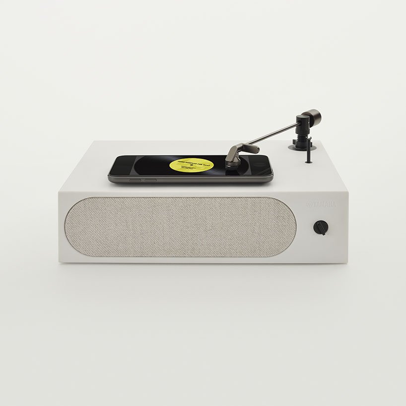 Esses acessórios de música interagem com seu celular Designboom Yamaha música (10) Objeto branco em forma de tocador de discos. Porém, em vez de discos, coloca-se o smartphone sobre o objeto e apoia-se a agulha na tela, onde a imagem de um disco de vinil gira ativando a música.