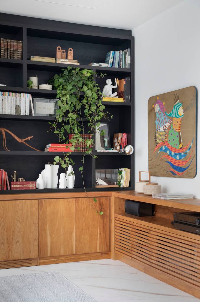 Janela-extensa-traz-a-natureza-para-dentro-deste-apartamento-de-150-m2-projeto-arquiteto-Henrique-Ramalho-@DenilsonMachadoMCA-rack-tv-arte Sala de estar com marcenaria preta e rack de madeira