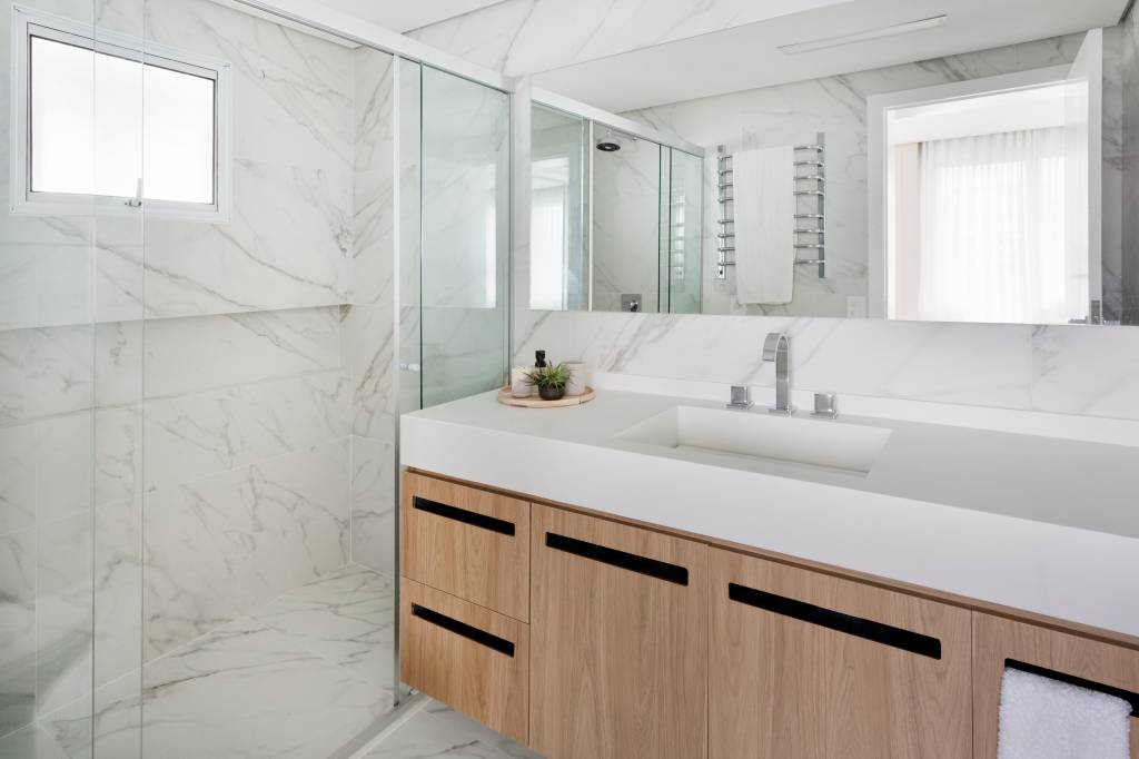 Painel-de-madeira-que-percorre-por-toda-a-sala-e-destaque-neste-ape-de-112m2-Projeto-Doob-Arquitetura-Foto-Julia-Ribeiro-banheiro-marcenaria-espelhos Banheiro com revestimento de mármore no piso e parede