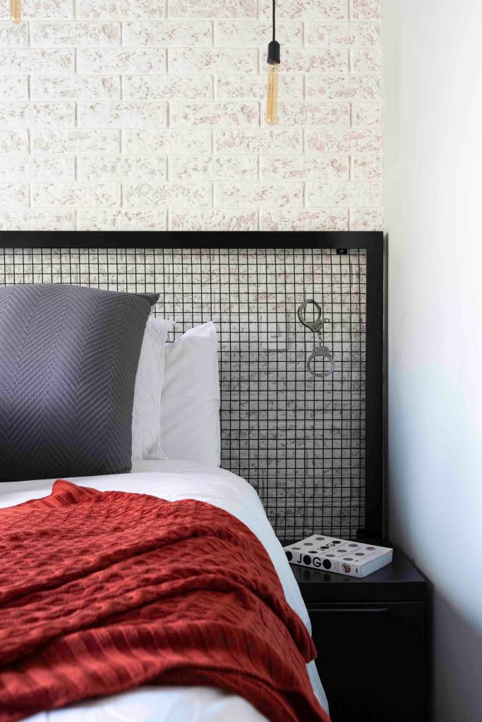Ape-de-90-m2-exibe-estilo-industrial-com-elementos-unicos-projeto-Priscila-Cox-foto-Monica-Assan-quarto-cabeceira-industrial Quarto com cabeceira em estilo grade