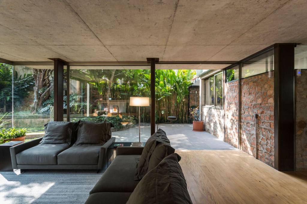 casa-paredes-de-entulho-massimo-failutti-sala-estar-varanda-jardim Na sala de estar, paredes de entulho na lateral se integram à varanda externa.