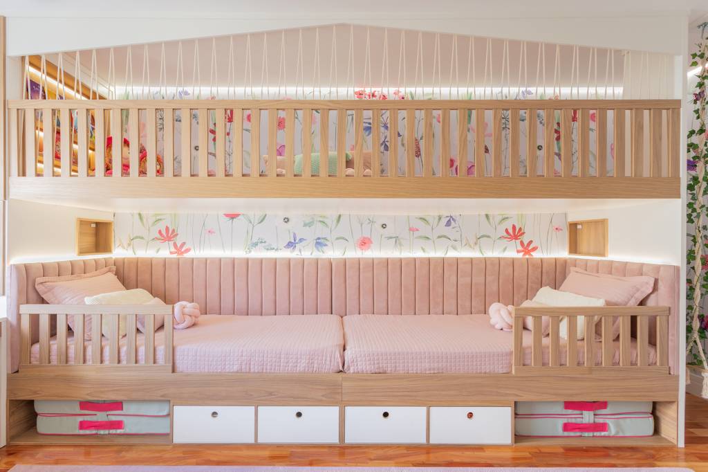 quarto-beliche-ll-arquitetura-credito-kelly-queiroz Trazendo um mundo do faz de conta para o quarto das meninas, a LL Arquitetura e Interiores projetou um espaço com uma atmosfera que parece ter saído de livros infantis para as irmãs de 3 e 7 anos. O diferencial é o design da cama beliche: a arquiteta aproveitou a parede lateral de 5 m de comprimento para criar uma grande casa alusiva à casa na árvore. As duas camas ficam no primeiro nível da “beliche”. Acima das camas, um espaço para brincar de casinha ou cabaninha e que também pode receber amigas para dormir.