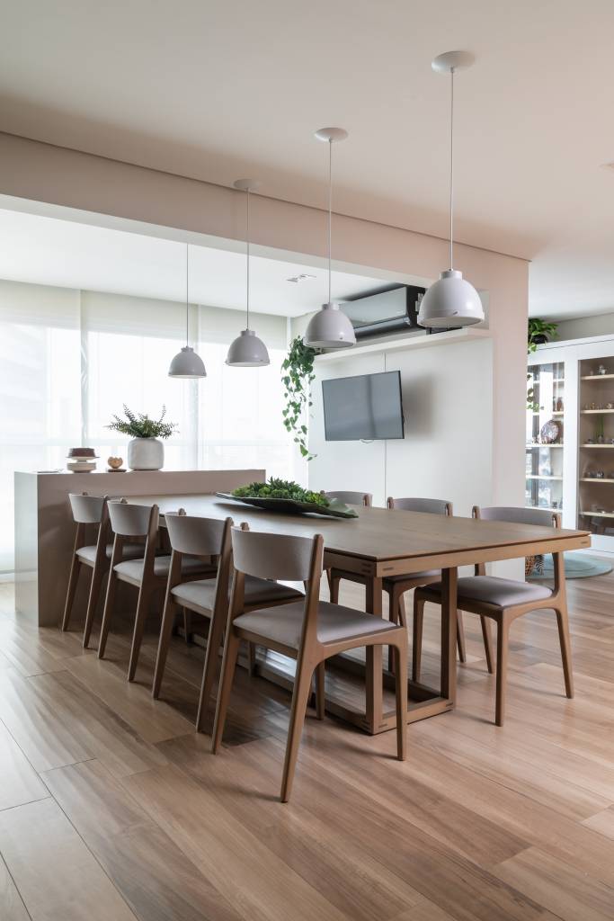 Sala de jantar integrada com estar e cozinha; piso vinílico; mesa de jantar com luminária