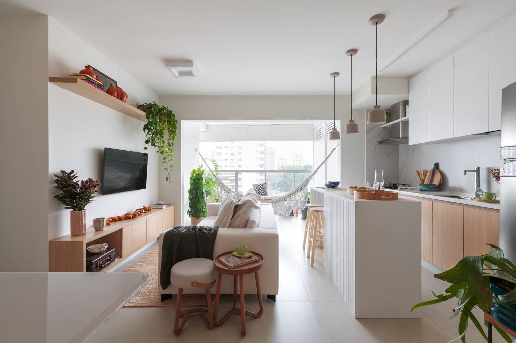 apartamento-de-70-m²-tem-rede-de-descanso-na-sala-e-decor-neutro (14) Apartamento 70 m² Estúdio Maré cozinha ilha bancada luminaria integrada sala tv varanda