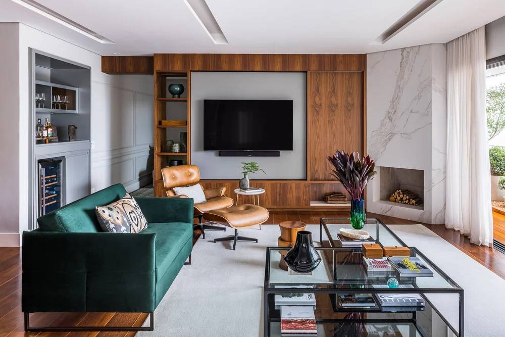estantes-abertas-fechadas-inteiras-ou-com-prateleiras-landhi-vivi-cirello-fotos-renato-navarro-03-sala-sofa-poltrona-eames Sala de tv; estante de madeira; sofá verde; poltrona eames lounge; tapete; mesa de centro de vidro