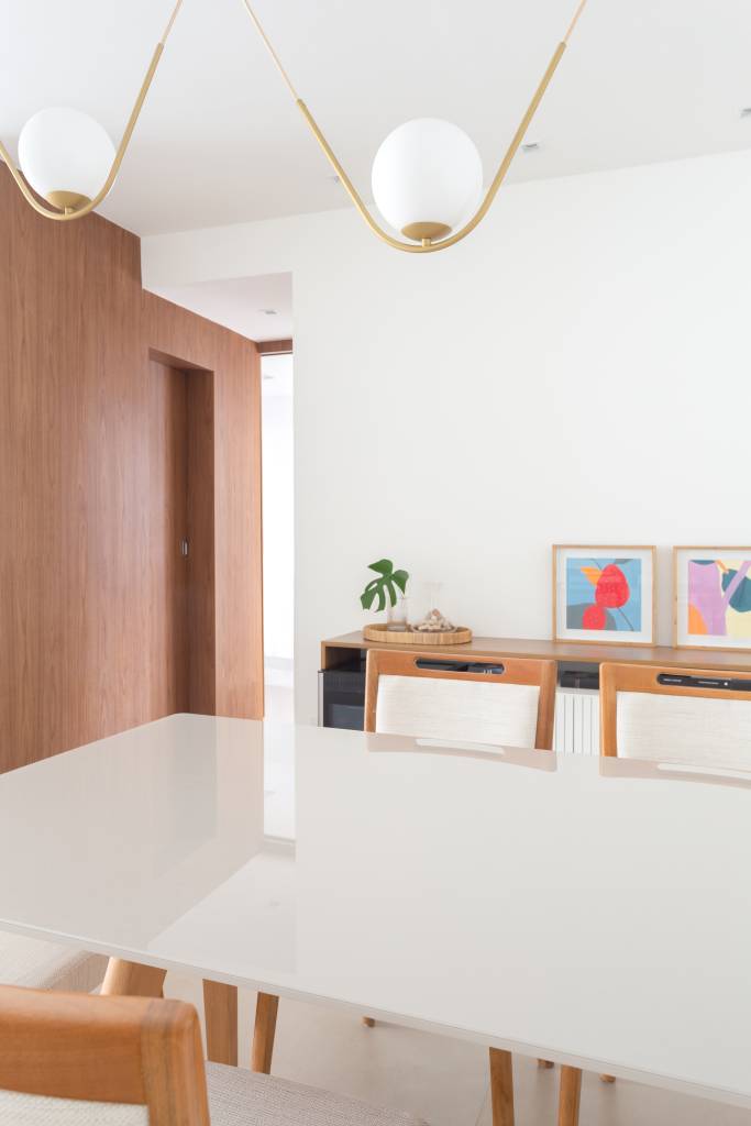 ape-125m-varanda-integrada-paleta-clara-piso-porcelanato-alice-costa-fotos-nadia-bach-03-sala-jantar-luminaria Sala de jantar; sala de jantar branca; mesa branca; luminária esférica pendente; cadeira de madeira
