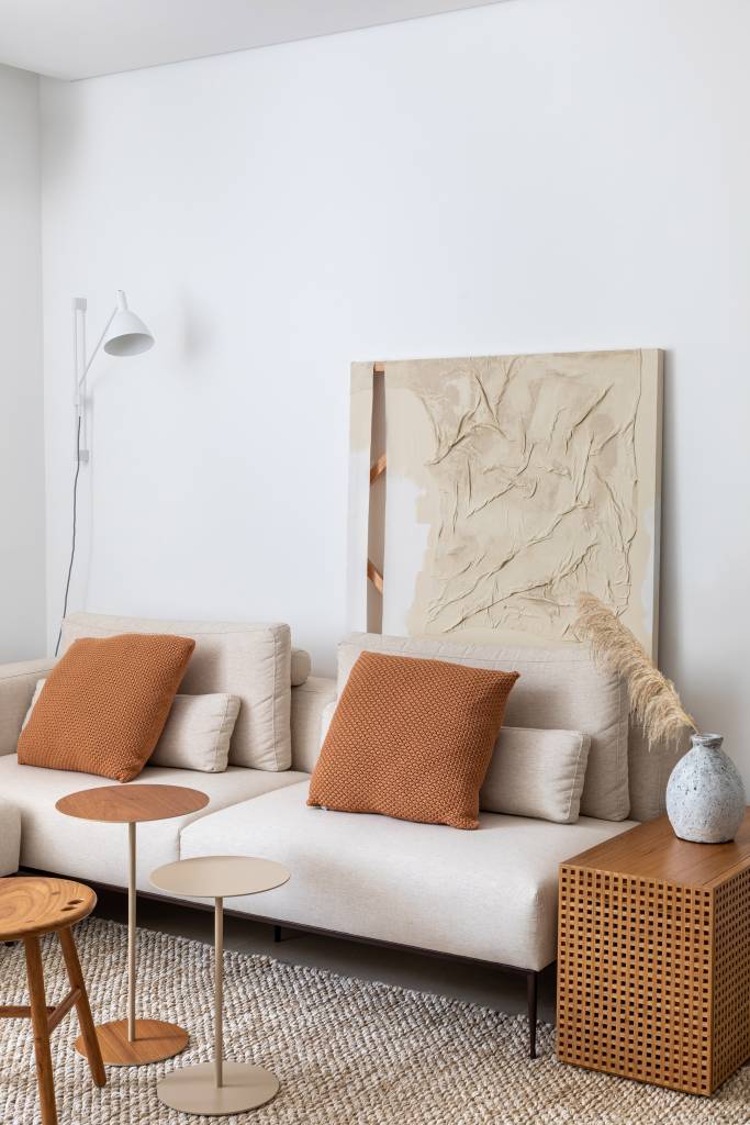essencial-minimalista-ape-80m-cozinha-americana-home-office-janaina-sthel-fotos-juliano-colodeti-08-sofa-quadro-luminaria-almofada Sala de estar; sofá branco; quadro atrás do sofá; almofada marrom; mesa de centro de madeira; mesa lateral de madeira