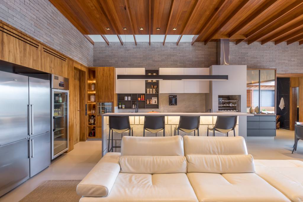 trama-de-paineis-de-madeira-articulaveis-casa-375m-truvian-arquitetura-fotos-leo-matsuda-15 Sala integrada; cozinha integrada; cozinha americana; área gourmet; sofá branco; bancada; banquetas