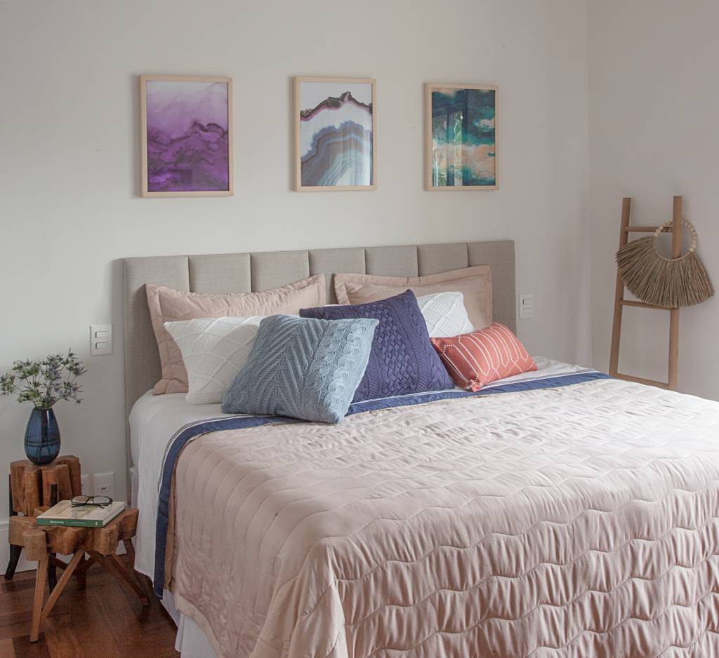 casa-tem-quarto-e-home-office-voltados-para-jardim-isabella-nalon-32 Quarto com cabeceira acolchoada, cama de casal e quadros sobre a cama.