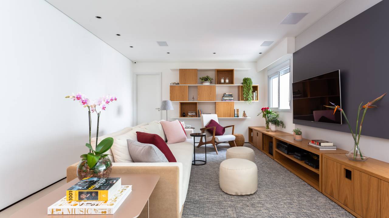 Sala de estar; sala de tv; sofá branco; tapete; pufe.