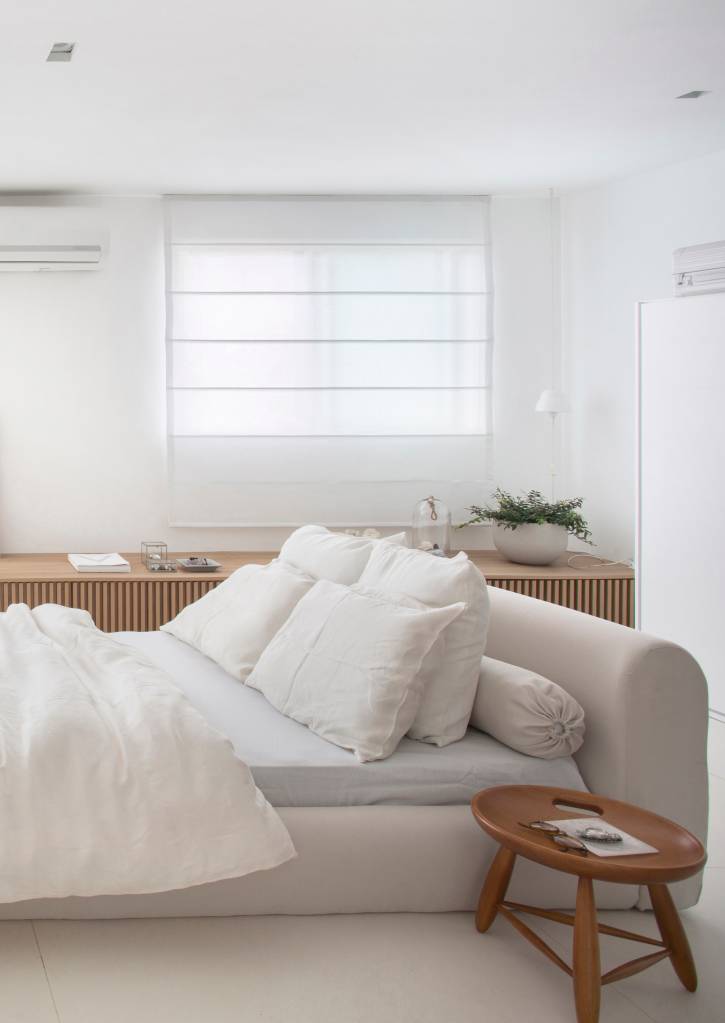ape-40m-transformado-loft-minimalista-diego-raposo-arquitetos-01-cama Cama baixa branca com cabeceira estofada.