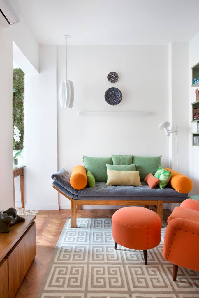 ape-de-70m-ganha-cara-nova-com-reforma-economica-ketlein-amorim-01-tapete-sofa Sala com varanda e sofá pequeno com almofadas coloridas.