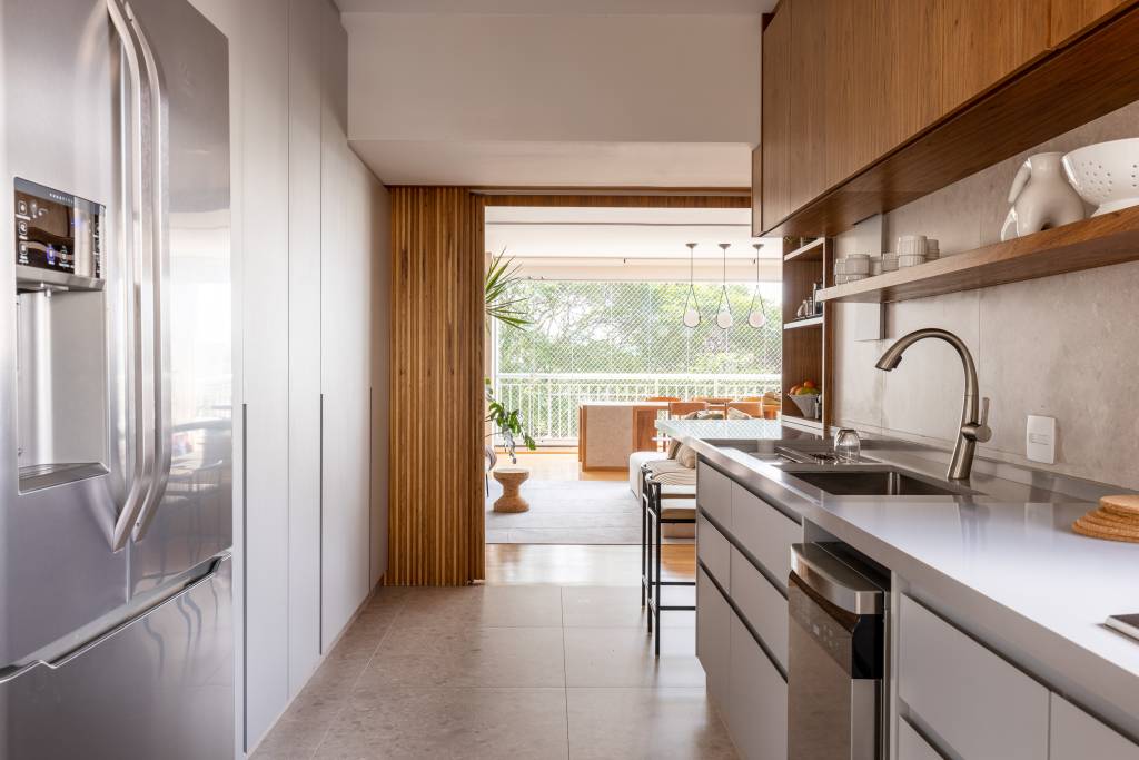 ape-integrado-140m-mesa-com-porcelanato-sofa-ilha-estudio-glik-interiores-06-cozinha Cozinha com porta de correr de madeira ripada.