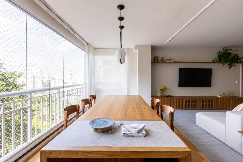 ape-integrado-140m-mesa-com-porcelanato-sofa-ilha-estudio-glik-interiores-09-gourmet-varanda Varanda integrada; área gourmet com mesa de madeira e churrasqueira.