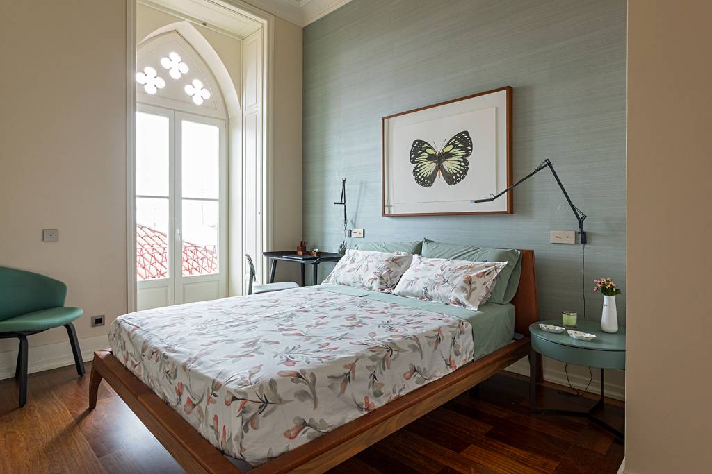 ape-portugal-reforma-decor-contemporaneo-tons-azuis-andrea-chicharo-12-quarto Quarto com cama de casal e roupa de cama floral. Quadro em cima da parede.