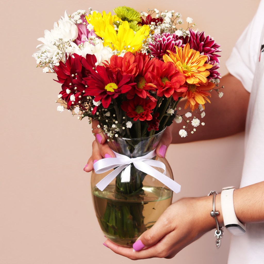 Buquê de flores coloridas em vaso de vidro.