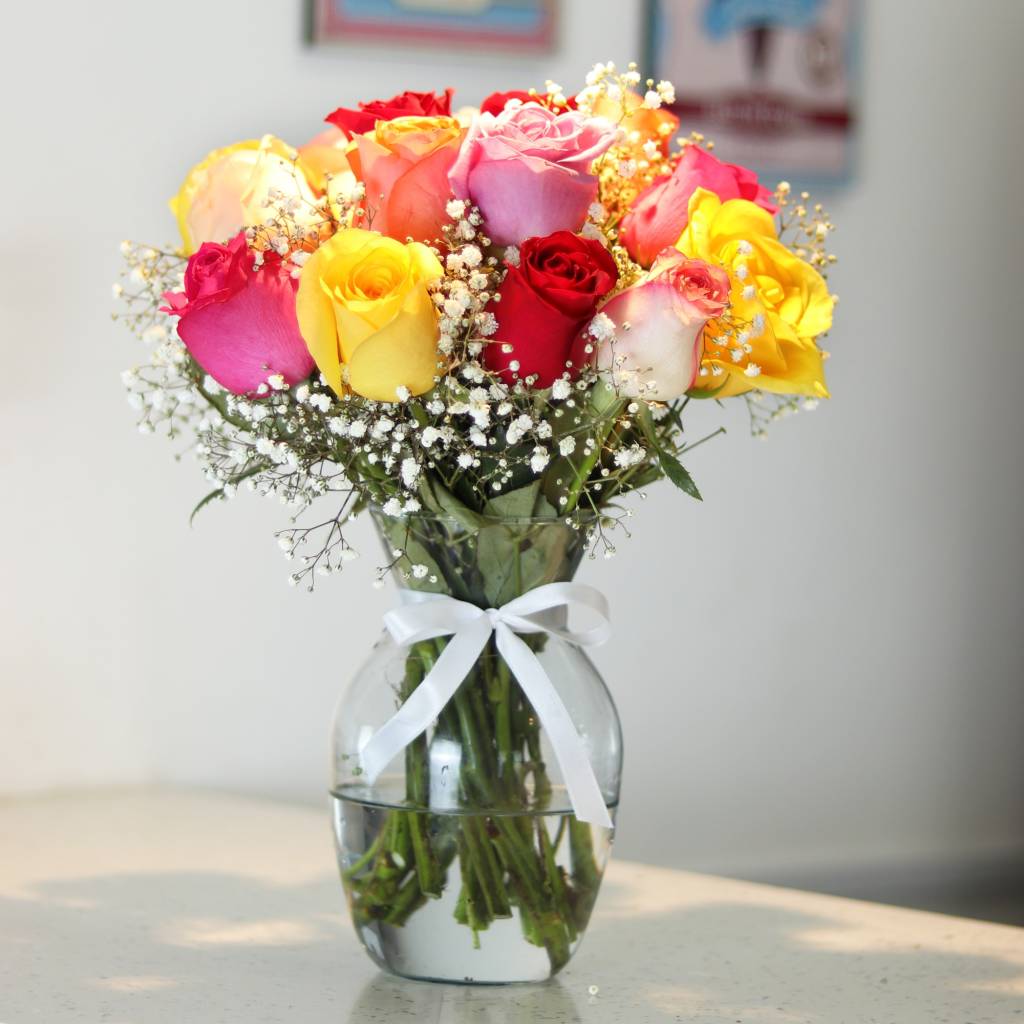 Buquê com rosas coloridas em vasos de vidro.