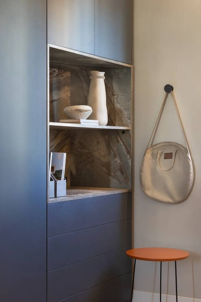 ganchos-cabideiros-na-decoracao-geovani-capelina-arquitetura-02 Home office com marcenaria e poltrona azul e gancho na parede.