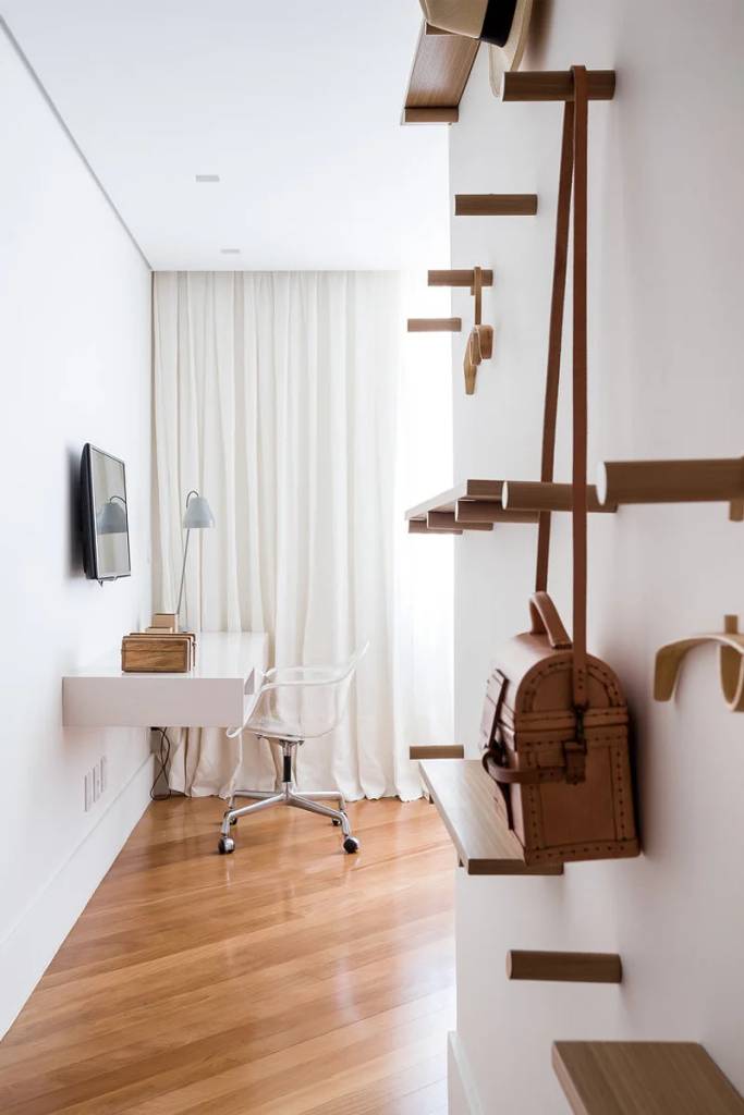 ganchos-cabideiros-na-decoracao-stugioag Home office branco com piso de madeira com ganchos de madeira na parede.