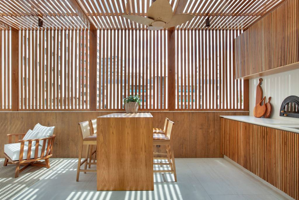 minimalismo-inspiracao-grega-marcam-apartamento-450m-diego-raposo-arquitetos-14-area-gourmet Área gourmet com cobertura de ripas de madeira e bancada de madeira.