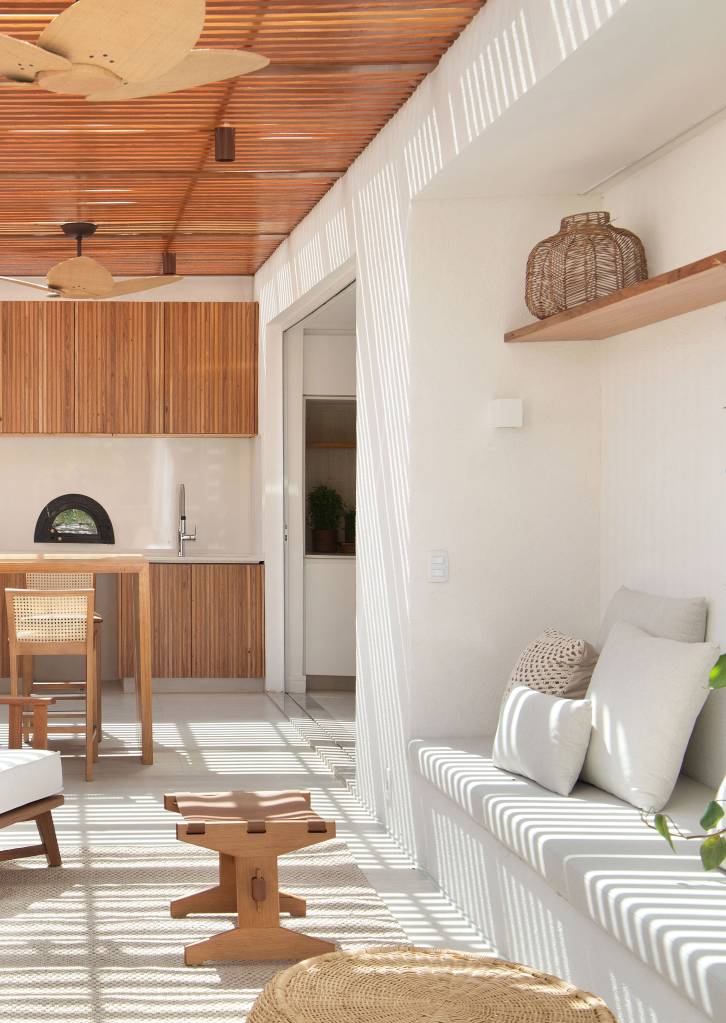minimalismo-inspiracao-grega-marcam-apartamento-450m-diego-raposo-arquitetos-15-area-gourmet-banco Área gourmet com cobertura de madeira ripada; banco branco esculpido na parede.