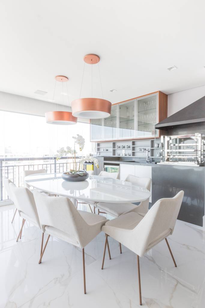 painel-com-duas-tvs-lareira-ambientes-integrados-ape-daniela-funari-22-varanda-gourmet Área gourmet em varanda integrada com mesa e cadeiras brancas.