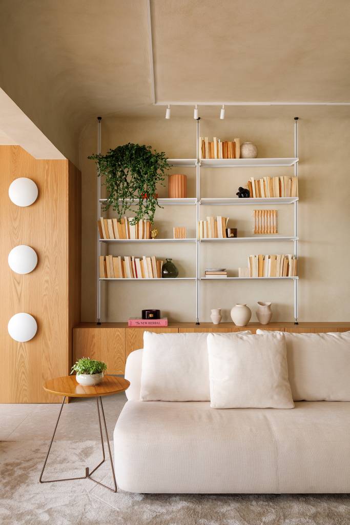 tons-areia-formas-arredondadas-atmosfera-mediterranea-ape-gustavo-marasca-08-sala-sofa-estante Sala com sofá branco e estante branca vazada.