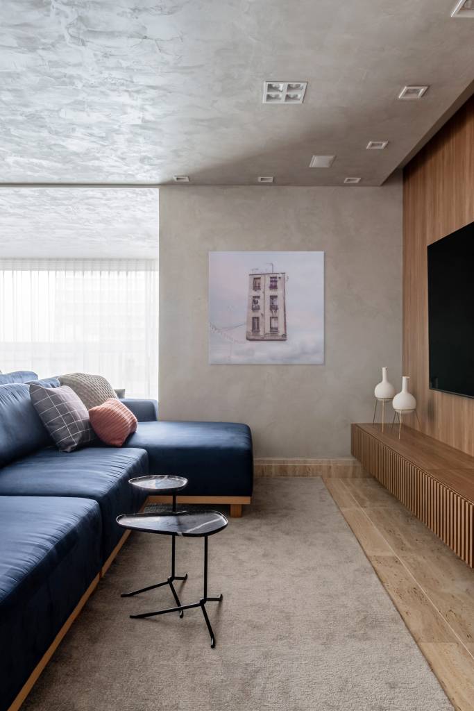 toques-de-azul-referencia-mar-ape-elegante-160m-studio-plano-arquitetura-07-sofa Sala de tv com parede revestida de cimento queimado e sofá azul