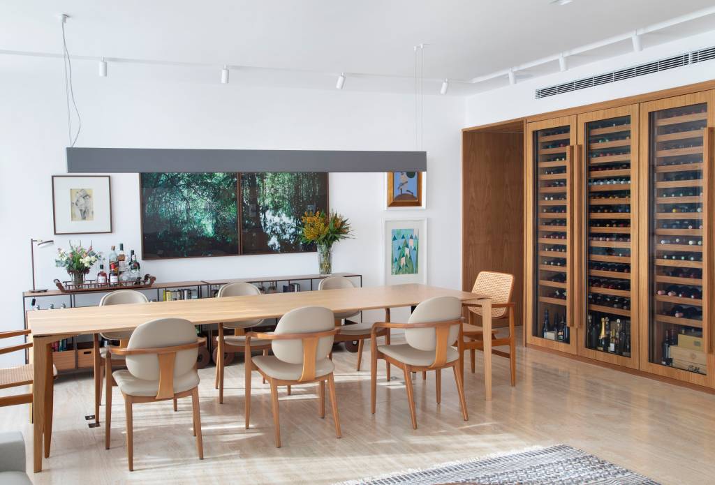 Sala de jantar com mesa de madeira e cadeiras de madeira; adega em marcenaria.