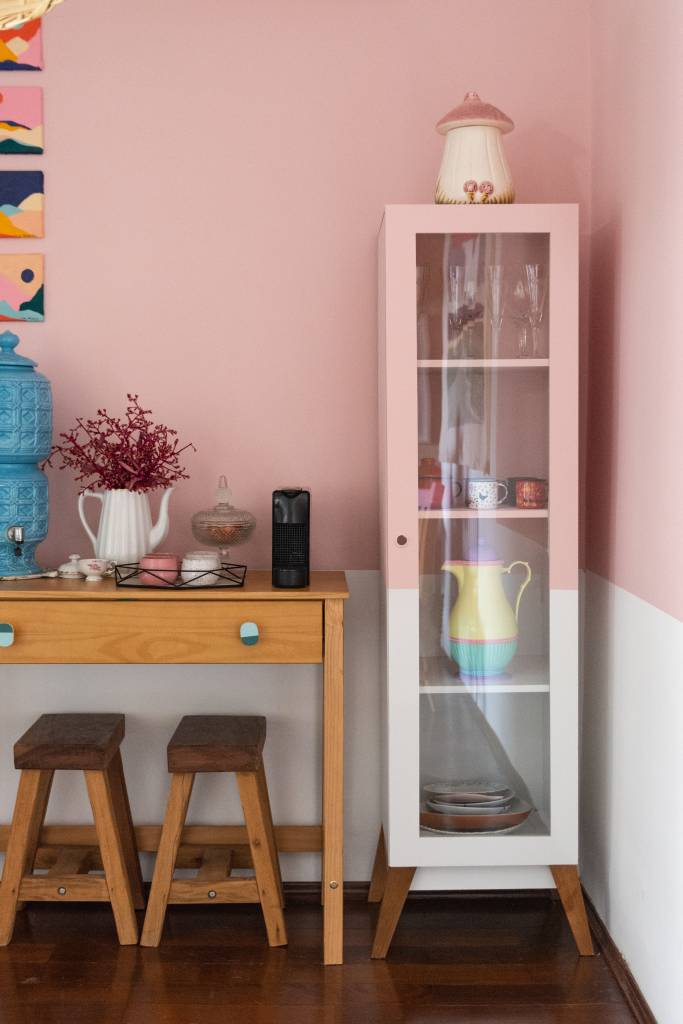 ape-80m-decoracao-memorias-paleta-de-cores-terrosa-sertao-arquitetos-08-cristaleira Sala de estar com meia parede rosa, aparador de madeira e cristaleira.