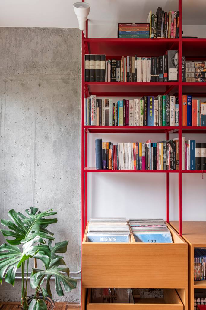estante-serralheria-vermelha-destaque-ape-100m-cota-760-arquitetura-02 Estante de serralheria vermelha com livros, banco e espaço para discos de vinil.