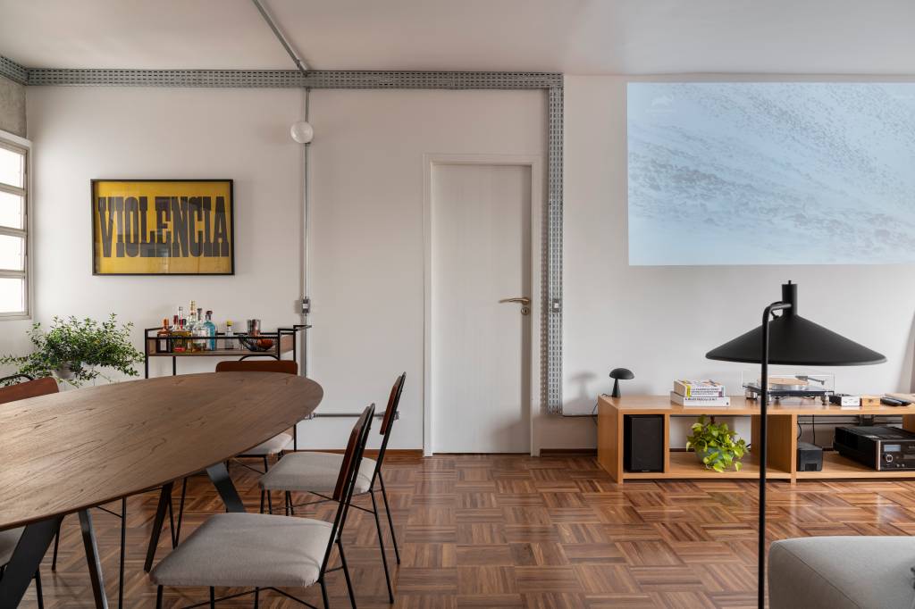 estante-serralheria-vermelha-destaque-ape-100m-cota-760-arquitetura-13 Sala com piso de madeira e quadro.