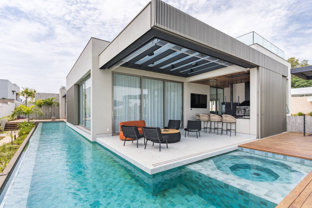 Área gourmet flutuar piscina casa 650 m2 Sabrina Salles Adriano Salles arquitetura piscina fachada jardim churrasqueira mesa pergolado